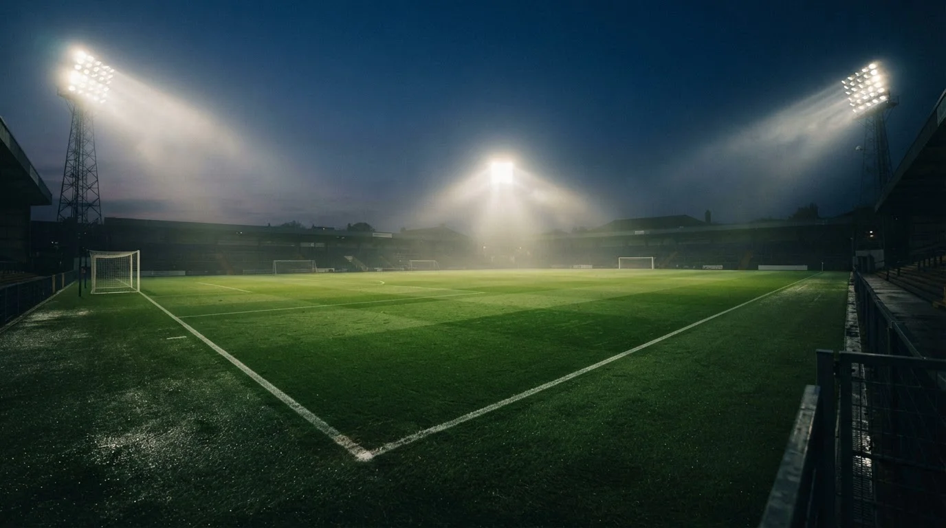 Fußballfeld in einem beleuchteten Stadion am Abend