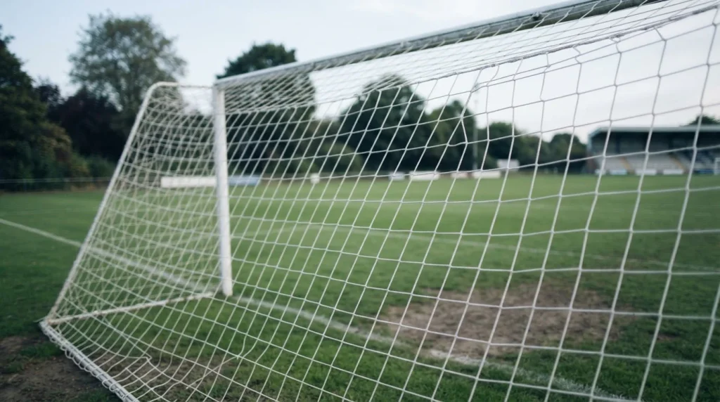 Fußballtor mit weißem Tornetz aus einer Perspektive unter der Latte